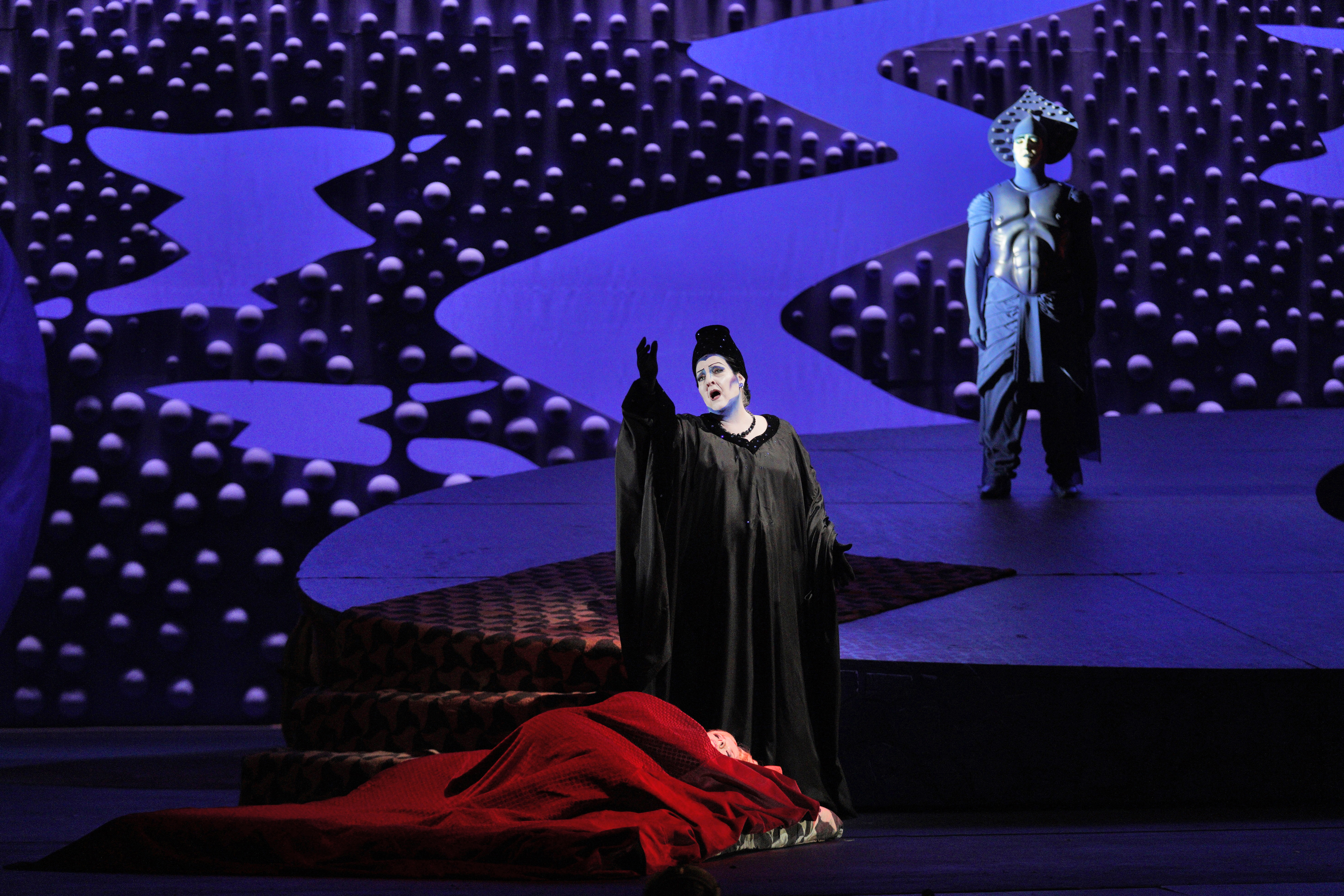 Die Frau ohne Schatten scene with woman in black sining over woman in red on the ground