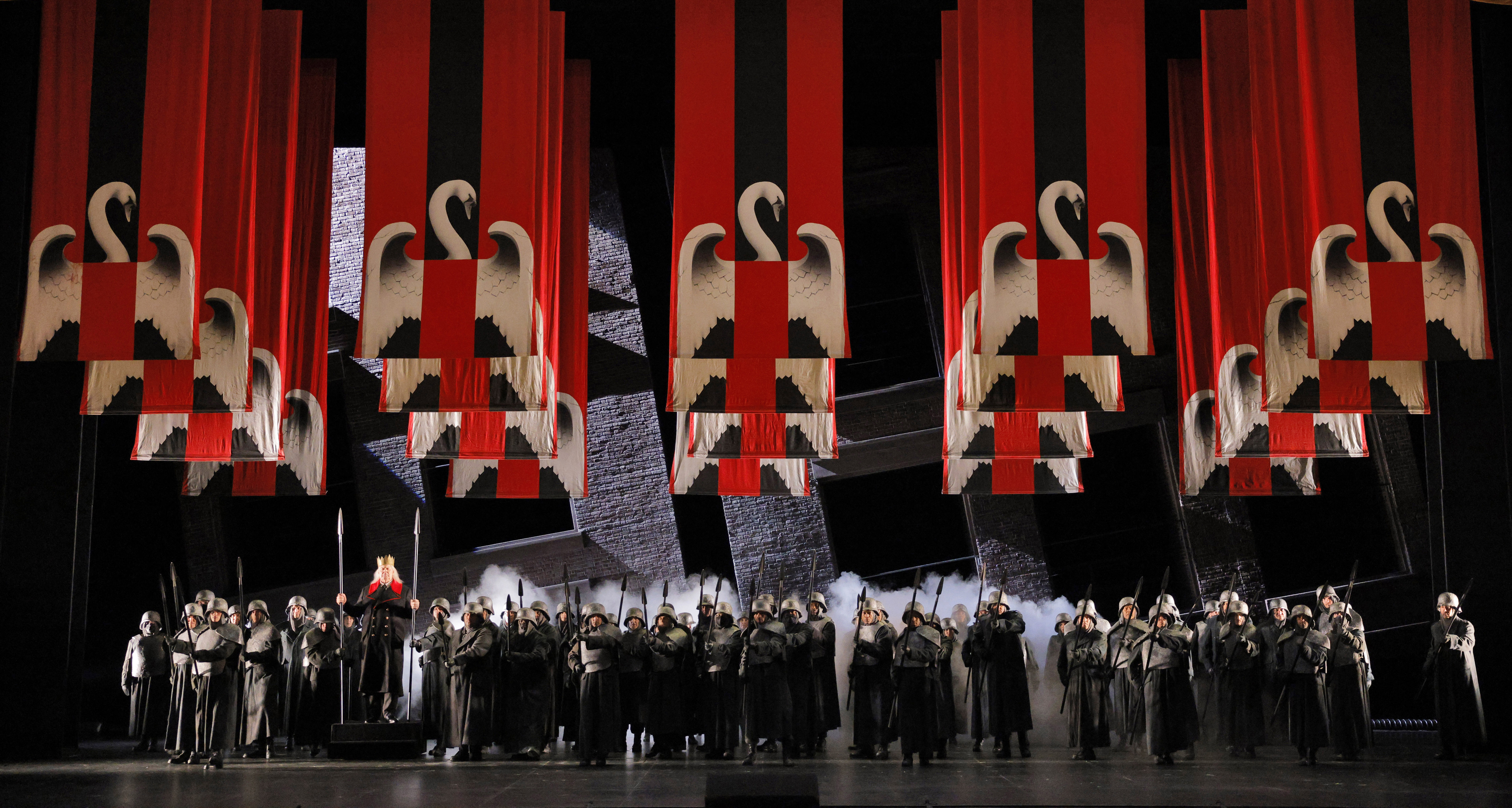 People on stage under lohengrin banners