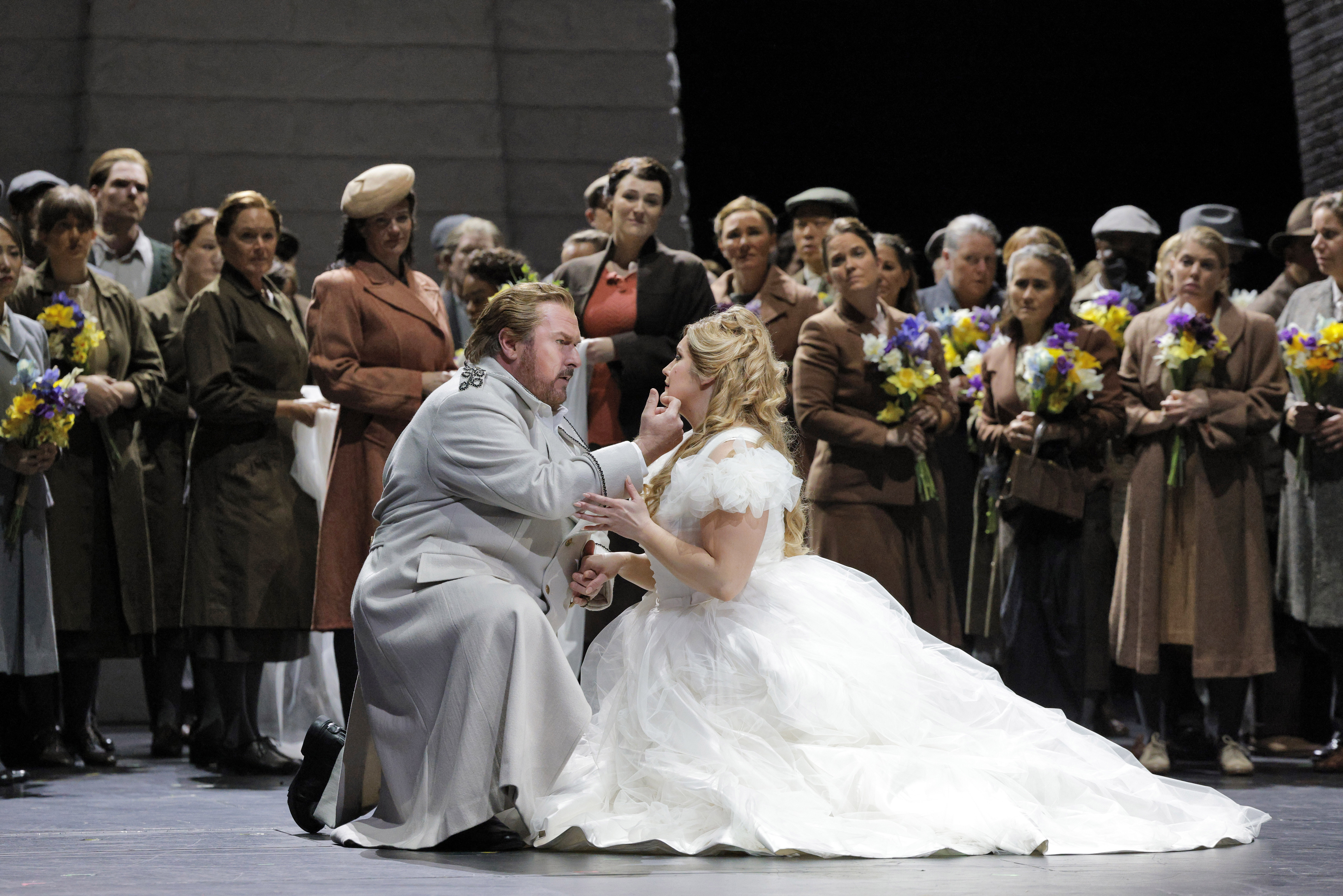 couple kneeling down on stage in front of onlookers