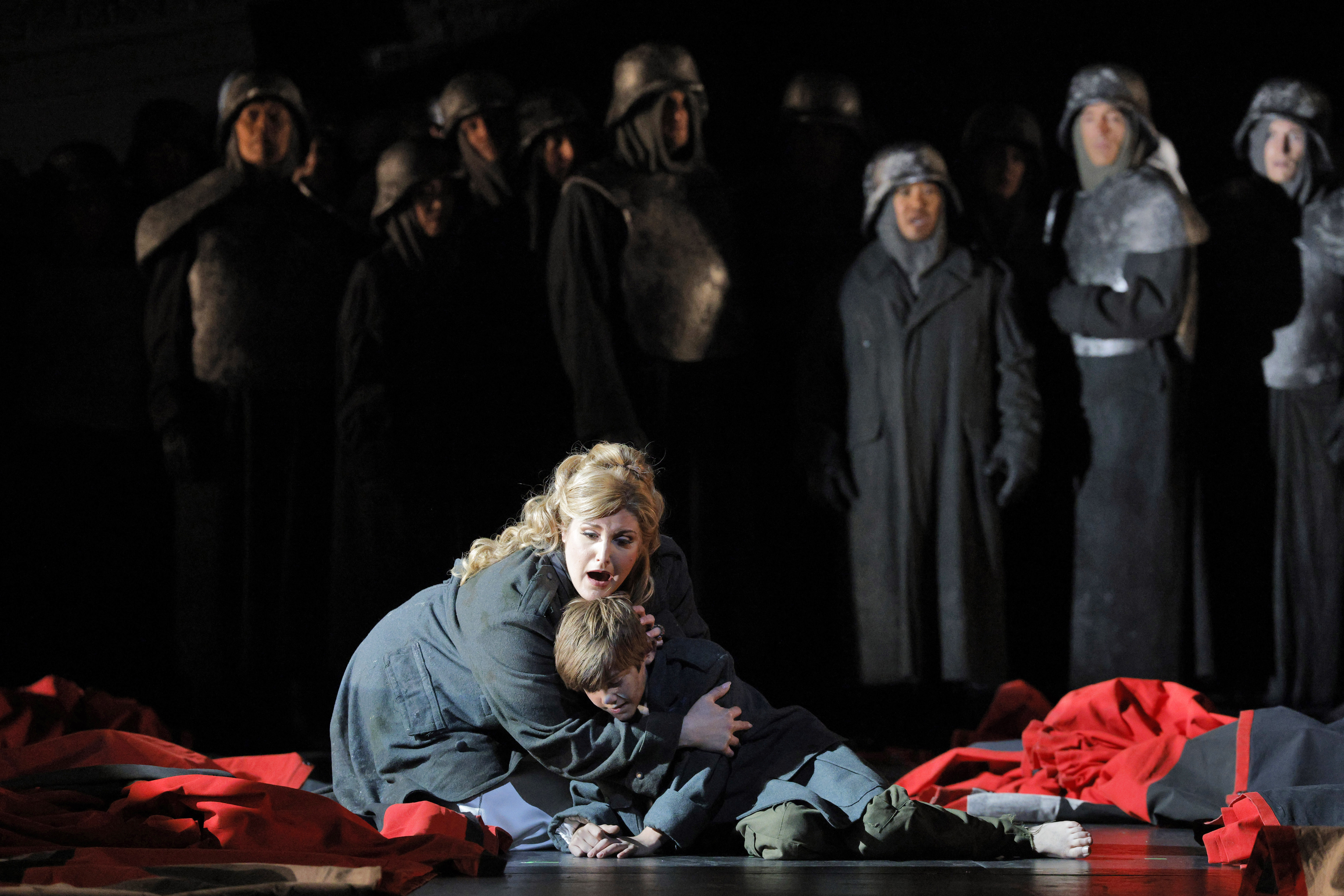 Women embracing child on ground (stage)